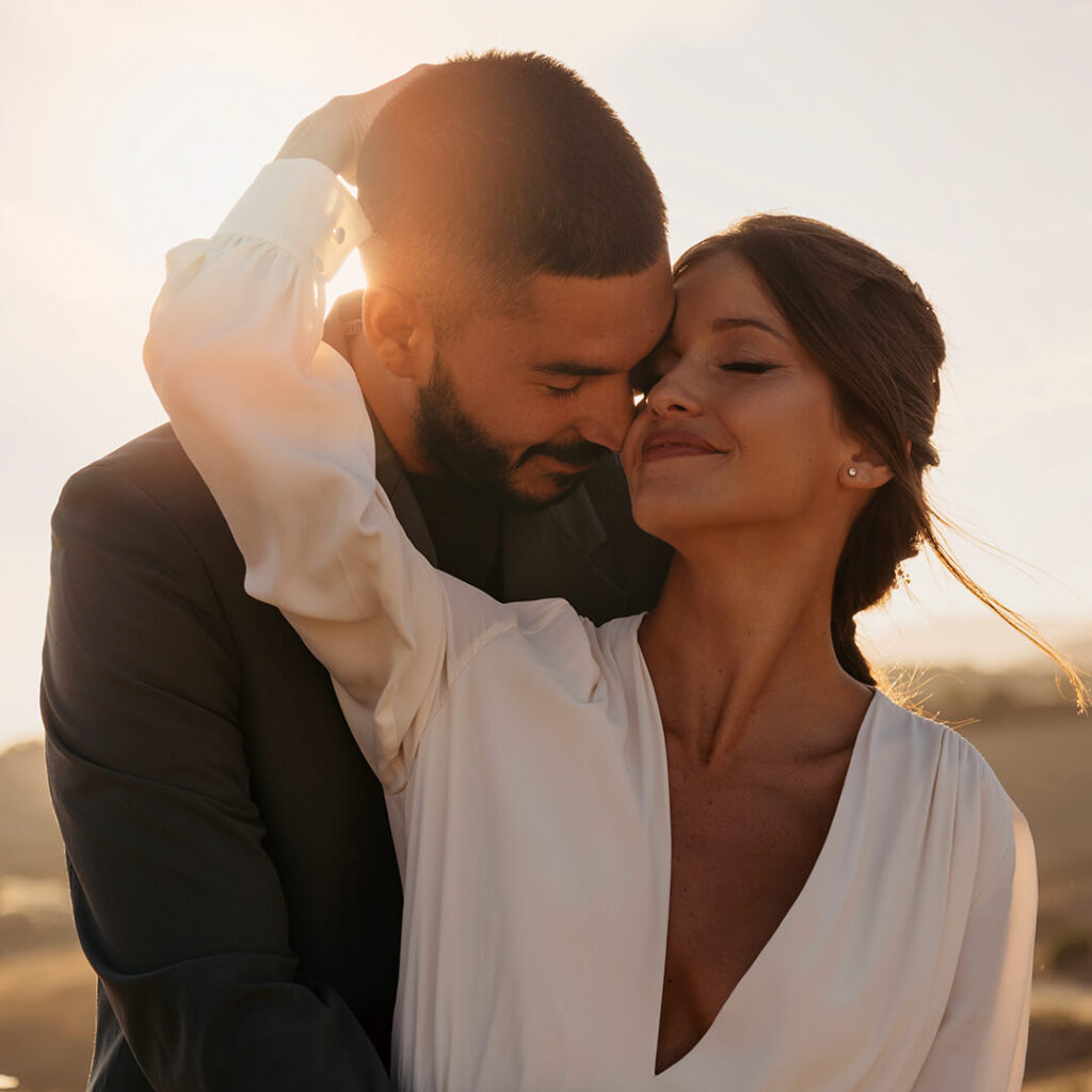 A couple embracing, with the man hugging the woman from behind and her responding affectionately, symbolizing the strengthened emotional and physical connection attributed to the benefits of Sexual Wellness Stem Cell Treatment.